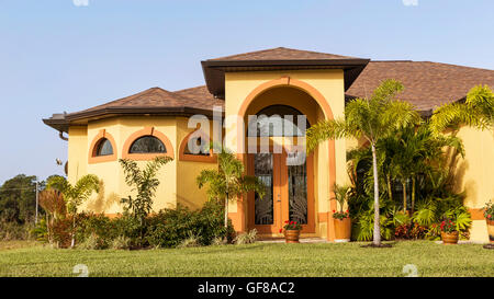 Typische Südwestflorida Betonblock und Stuck zu Hause, in der Landschaft mit Palmen, tropischen Pflanzen und Blumen, Rasen Stockfoto