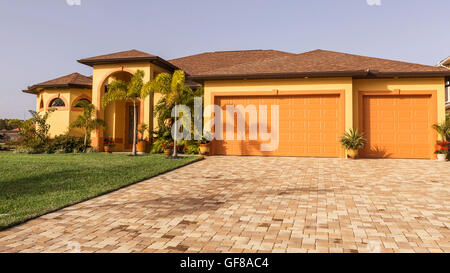 Typische Südwestflorida Betonblock und Stuck zu Hause, in der Landschaft mit Palmen, tropischen Pflanzen und Blumen, Rasen Stockfoto