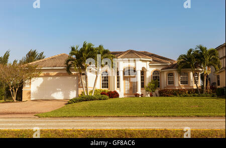 Typische Südwestflorida Betonblock und Stuck zu Hause, in der Landschaft mit Palmen, tropischen Pflanzen und Blumen, Rasen Stockfoto