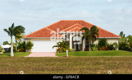 Typische Südwestflorida Betonblock und Stuck zu Hause, in der Landschaft mit Palmen, tropischen Pflanzen und Blumen, Rasen Stockfoto