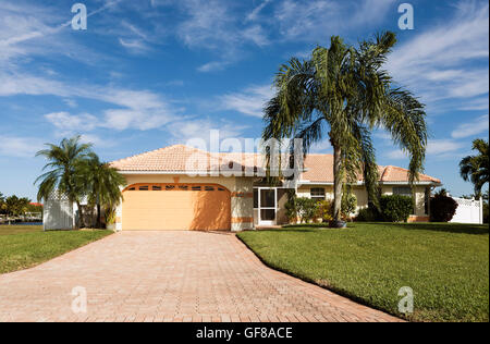 Typische Südwestflorida Betonblock und Stuck zu Hause, in der Landschaft mit Palmen, tropischen Pflanzen und Blumen, Rasen Stockfoto