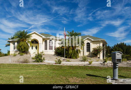 Typische Südwestflorida Betonblock und Stuck zu Hause, in der Landschaft mit Palmen, tropischen Pflanzen und Blumen, Rasen Stockfoto