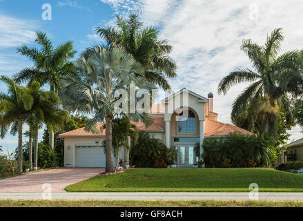 Typische Südwestflorida Betonblock und Stuck zu Hause, in der Landschaft mit Palmen, tropischen Pflanzen und Blumen, Rasen Stockfoto