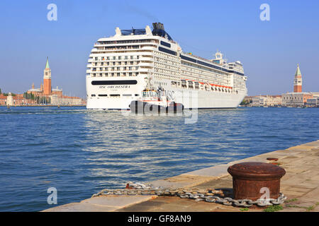 Die MSC Orchestra Kreuzfahrt Schiff Segeln entlang der Insel San Giorgio Maggiore (links) und der Dogenpalast (rechts) in Venedig, Italien Stockfoto