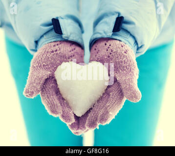 Weibliche Hände mit verschneiten Herzen Stockfoto