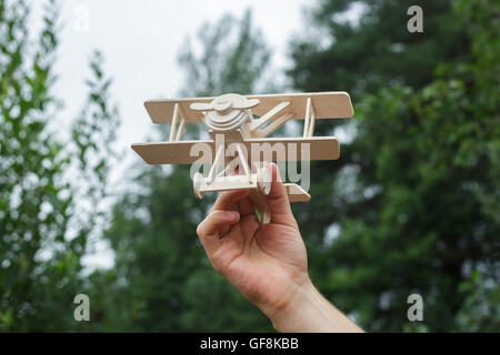 Holzmodell Flugzeug in den Händen des weißen Mannes. Stockfoto