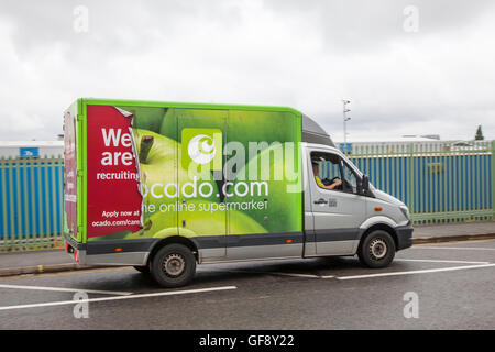 Ocado Apple Van livery & Morrisons Supermarkt Lebensmittel Lieferservice Food Store Fahrzeuge; online Fuhrpark liefern, Lebensmittel und Dinge des tägl. Bedarfs in Liverpool, Merseyside, UK Stockfoto