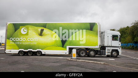 Ocado Apple Van livery & Morrisons Supermarkt Lebensmittel Lieferservice Food Store Fahrzeuge; online Fuhrpark liefern, Lebensmittel und Dinge des tägl. Bedarfs in Liverpool, Merseyside, UK Stockfoto