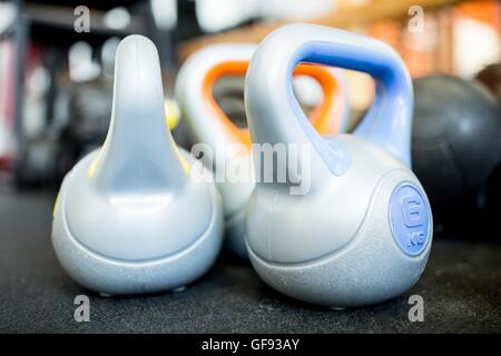 EIGENTUM FREIGEGEBEN. Nahaufnahme von schweren Kettlebells auf Boden gehalten. Stockfoto