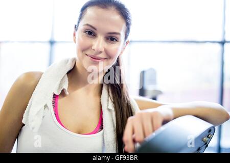 EIGENTUM FREIGEGEBEN. -MODELL VERÖFFENTLICHT. Porträt der jungen Frau mit Serviette um Hals im Fitness-Studio. Stockfoto