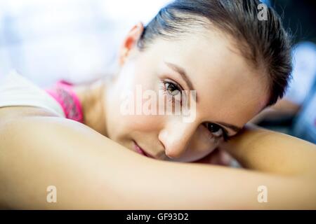 EIGENTUM FREIGEGEBEN. -MODELL VERÖFFENTLICHT. Close-up jungen Frau ruht auf Heimtrainer im Fitness-Studio, Porträt. Stockfoto