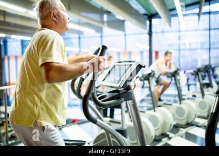 EIGENTUM FREIGEGEBEN. -MODELL VERÖFFENTLICHT. Senior woman auf Übung Laufband im Fitnessstudio trainieren. Stockfoto