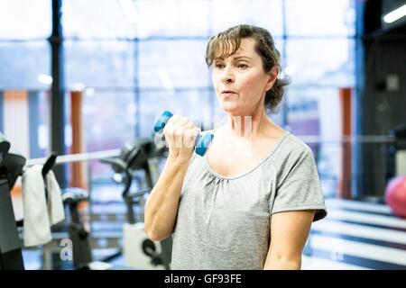 EIGENTUM FREIGEGEBEN. -MODELL VERÖFFENTLICHT. Ältere Frau mit Hantel im Fitness-Studio. Stockfoto