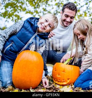 -MODELL VERÖFFENTLICHT. Familie machen Halloween-Kürbis. Stockfoto