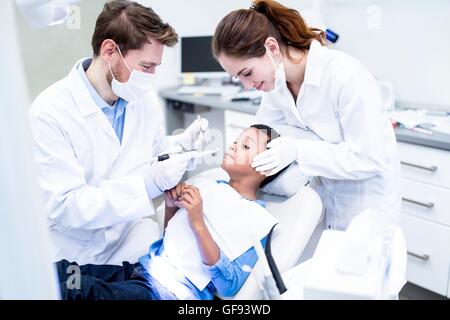 -MODELL VERÖFFENTLICHT. Angst, junge Zahnbohrer in der Hand des Zahnarztes zu betrachten. Stockfoto