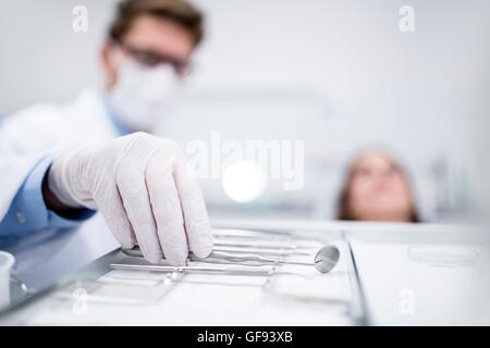 -MODELL VERÖFFENTLICHT. Zahnarzt mit abgewinkelten Spiegel in Zahnarzt Klinik. Stockfoto