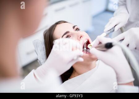 -MODELL VERÖFFENTLICHT. Junge Frau bekommen ihre Zähne vom Zahnarzt untersucht. Stockfoto