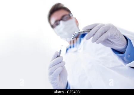 -MODELL VERÖFFENTLICHT. Zahnarzt Holding abgewinkelten Spiegel. Stockfoto