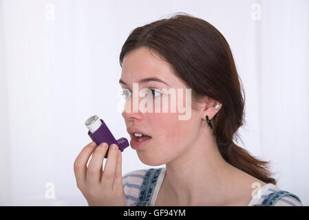 -MODELL VERÖFFENTLICHT. Teenager-Mädchen mit Asthma-Inhalator. Stockfoto