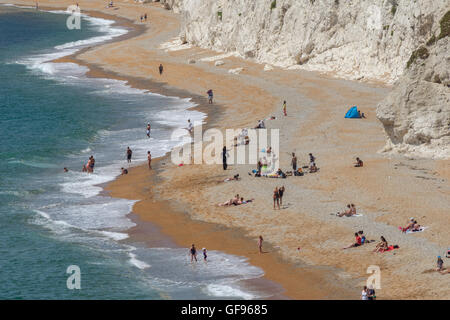 Durdle Door Strand an der Südküste des Vereinigten Königreichs an einem warmen Julitag. Viele Touristen genießen das warme Wetter. Stockfoto