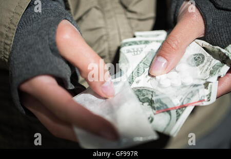 Nahaufnahme eines Süchtigen Hände mit Drogen und Geld Stockfoto
