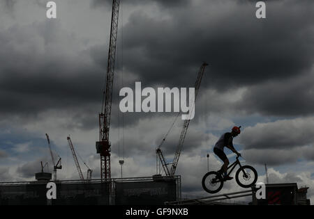 Ein Radfahrer zeigt seine Fähigkeiten bei einem Drop and Roll Display, während die aufsichtsrechtlichen RideLondon Grand Prix in Lee Valley VeloPark, Queen Elizabeth Olympic Park in London. Stockfoto