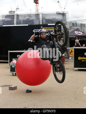 Schottische Studien Radfahrer Danny Macaskill zeigt seine Fähigkeiten bei einem Drop and Roll Display, während die aufsichtsrechtlichen RideLondon Grand Prix in Lee Valley VeloPark, Queen Elizabeth Olympic Park in London. Stockfoto