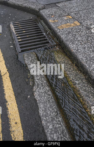 Straße Entwässerung/Rinne in Truro, Cornwall. Visuelle Metapher für "Geld in den Sand und Wasser/Abwasser. Stockfoto