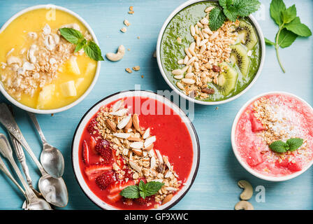 Gesunden Sommer Frühstück Konzept. Bunte Obst Smoothie Schalen auf türkis blauem Hintergrund Stockfoto