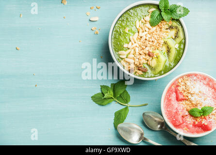 Gesunden Sommer Frühstück Konzept. Bunte Obst Smoothie Schalen auf türkis blauem Hintergrund Stockfoto