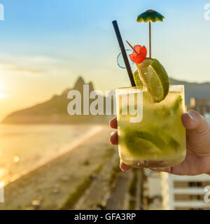 Eine köstliche Kiwi Caipirinha Drink mit Blick auf den berühmten Strand von Ipanema in Rio De Janeiro, Brasilien Stockfoto