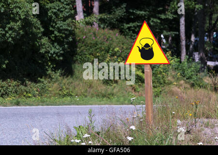 Gelbes Schild mit Wasserkocher oder Teekanne am Straßenrand. Stockfoto