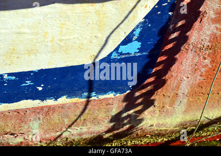 Detail der Farbe auf der Seite des Bootes mit Schatten der Ankerkette Stockfoto