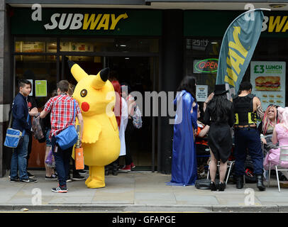 Pikachu entdeckt die kurze mollig gelb Pokemon unterwegs in Manchester auch unter eine Minute, um etwas zu Essen an der u-Bahn zu greifen. Stockfoto