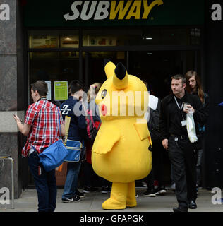 Pikachu entdeckt die kurze mollig gelb Pokemon unterwegs in Manchester auch unter eine Minute, um etwas zu Essen an der u-Bahn zu greifen. Stockfoto