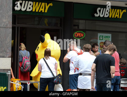 Pikachu entdeckt die kurze mollig gelb Pokemon unterwegs in Manchester auch unter eine Minute, um etwas zu Essen an der u-Bahn zu greifen. Stockfoto