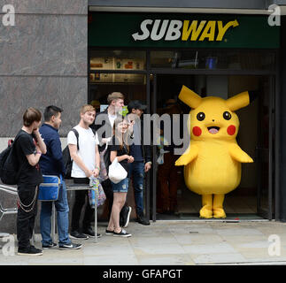 Pikachu entdeckt die kurze mollig gelb Pokemon unterwegs in Manchester auch unter eine Minute, um etwas zu Essen an der u-Bahn zu greifen. Stockfoto