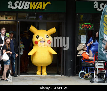 Pikachu entdeckt die kurze mollig gelb Pokemon unterwegs in Manchester auch unter eine Minute, um etwas zu Essen an der u-Bahn zu greifen. Stockfoto