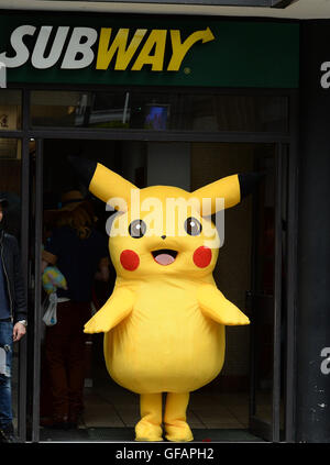 Pikachu entdeckt die kurze mollig gelb Pokemon unterwegs in Manchester auch unter eine Minute, um etwas zu Essen an der u-Bahn zu greifen. Stockfoto