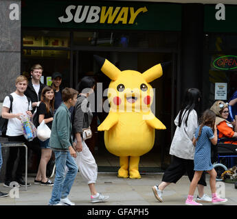 Pikachu entdeckt die kurze mollig gelb Pokemon unterwegs in Manchester auch unter eine Minute, um etwas zu Essen an der u-Bahn zu greifen. Stockfoto