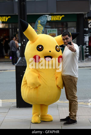 Pikachu entdeckt die kurze mollig gelb Pokemon unterwegs in Manchester auch unter eine Minute, um etwas zu Essen an der u-Bahn zu greifen. Stockfoto