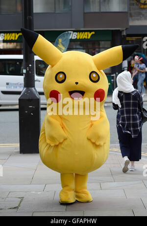 Pikachu entdeckt die kurze mollig gelb Pokemon unterwegs in Manchester auch unter eine Minute, um etwas zu Essen an der u-Bahn zu greifen. Stockfoto