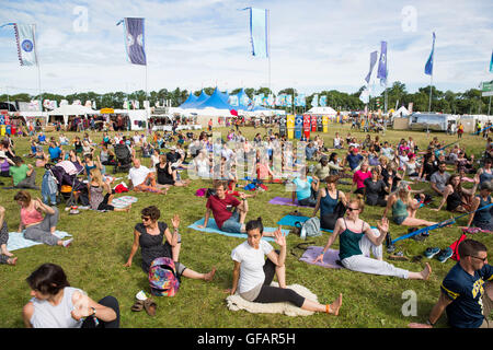 Charlton Park, UK. 30. Juli 2016. Hunderte von Menschen beteiligen sich an einer Yoga-Sitzung morgen Gruppe an einem sonnigen WOMAD Festival, 30. Juli 2016. Bildnachweis: Adam Gasson/Alamy Live-Nachrichten Stockfoto