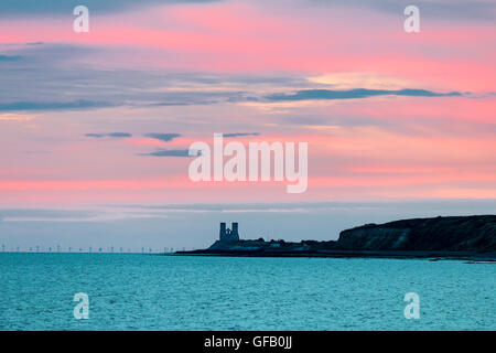 Herne Bay, England. Dawn brechen über die Fast silhouette Twin Towers von Reculver angelsächsischen Kirche auf der Landspitze ragt in die smaragdgrünen Farbe Meer. Himmel über Rot und Lila mit einigen Cloud. Stockfoto