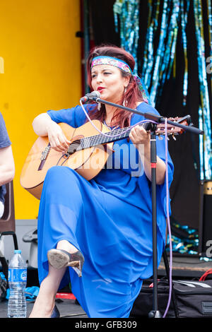 Kolumbianische Songwriter, Sänger und Gitarrist, Carolina Herrera in blauem Kleid, Gitarre spielen und Singen, während auf einer Open Air Bühne in Ramsgate. Stockfoto