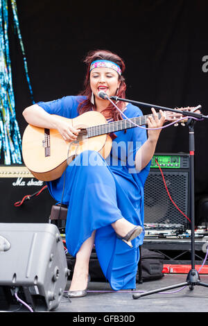 Kolumbianische Songwriter, Sänger und Gitarrist, Carolina Herrera in blauem Kleid, Gitarre spielen und Singen, während auf einer Open Air Bühne in Ramsgate. Stockfoto