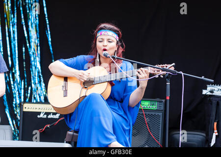 Kolumbianische Songwriter, Sänger und Gitarrist, Carolina Herrera in blauem Kleid, Gitarre spielen und Singen, während auf einer Open Air Bühne in Ramsgate. Stockfoto