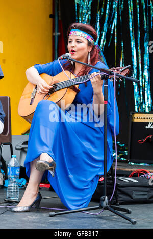 Kolumbianische Songwriter, Sänger und Gitarrist, Carolina Herrera in blauem Kleid, Gitarre spielen und Singen, während auf einer Open Air Bühne in Ramsgate. Stockfoto