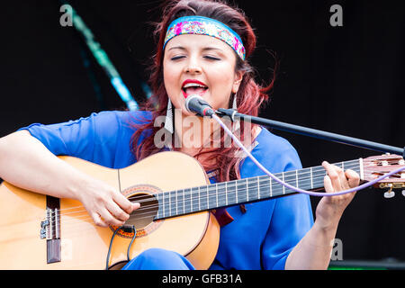 Kolumbianische Songwriter, Sänger und Gitarrist, Carolina Herrera in blauem Kleid, Gitarre spielen und Singen, während auf einer Open Air Bühne in Ramsgate. Stockfoto