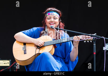 Kolumbianische Songwriter, Sänger und Gitarrist, Carolina Herrera in blauem Kleid, Gitarre spielen und Singen, während auf einer Open Air Bühne in Ramsgate. Stockfoto